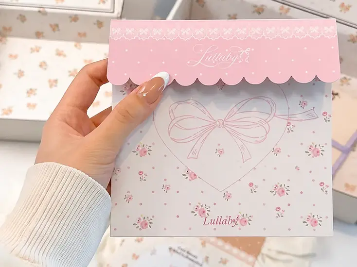 Coordinated floral packaging card held in front of mailer boxes