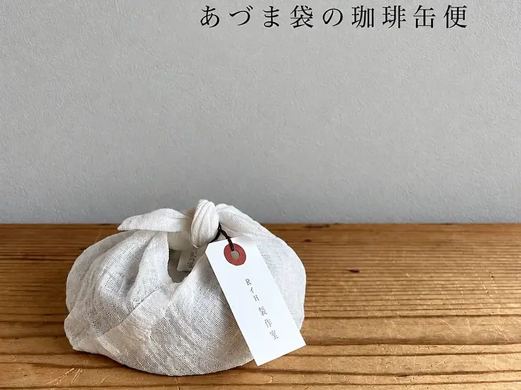Small tied fabric gift pouch with a paper tag
