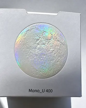 Paperboard carton with raised circular holographic decoration