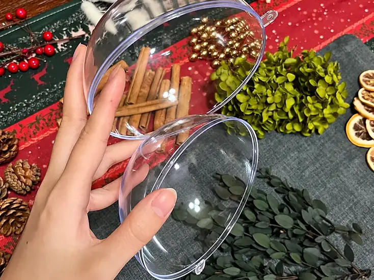 Clear ornament halves alongside botanical gift decorations