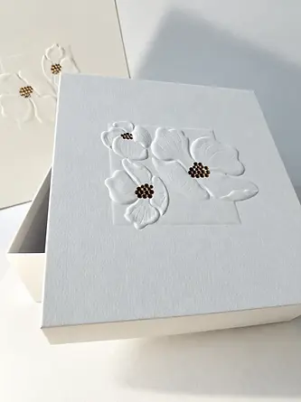 White paper greeting card with embossed floral decoration