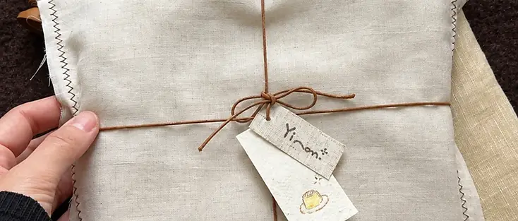 Folded fabric wrap tied with string and a paper hang tag