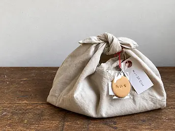 Fabric gift pouch tied at the top with paper tags
