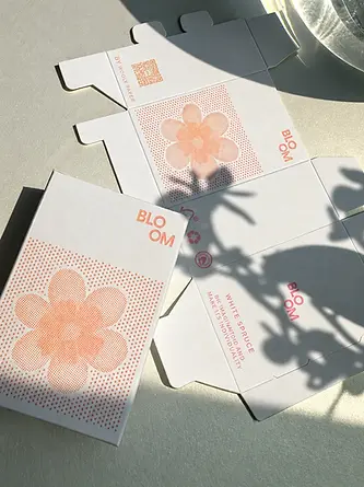 Printed textured paperboard folding carton with floral artwork — assembled or flat view