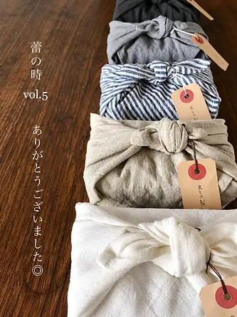 Assorted fabric gift wraps with tags and tied closures