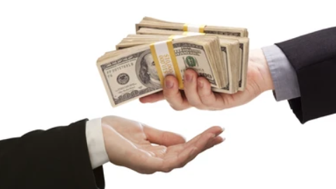 A stack of $10,000 in $100 bills being handed over