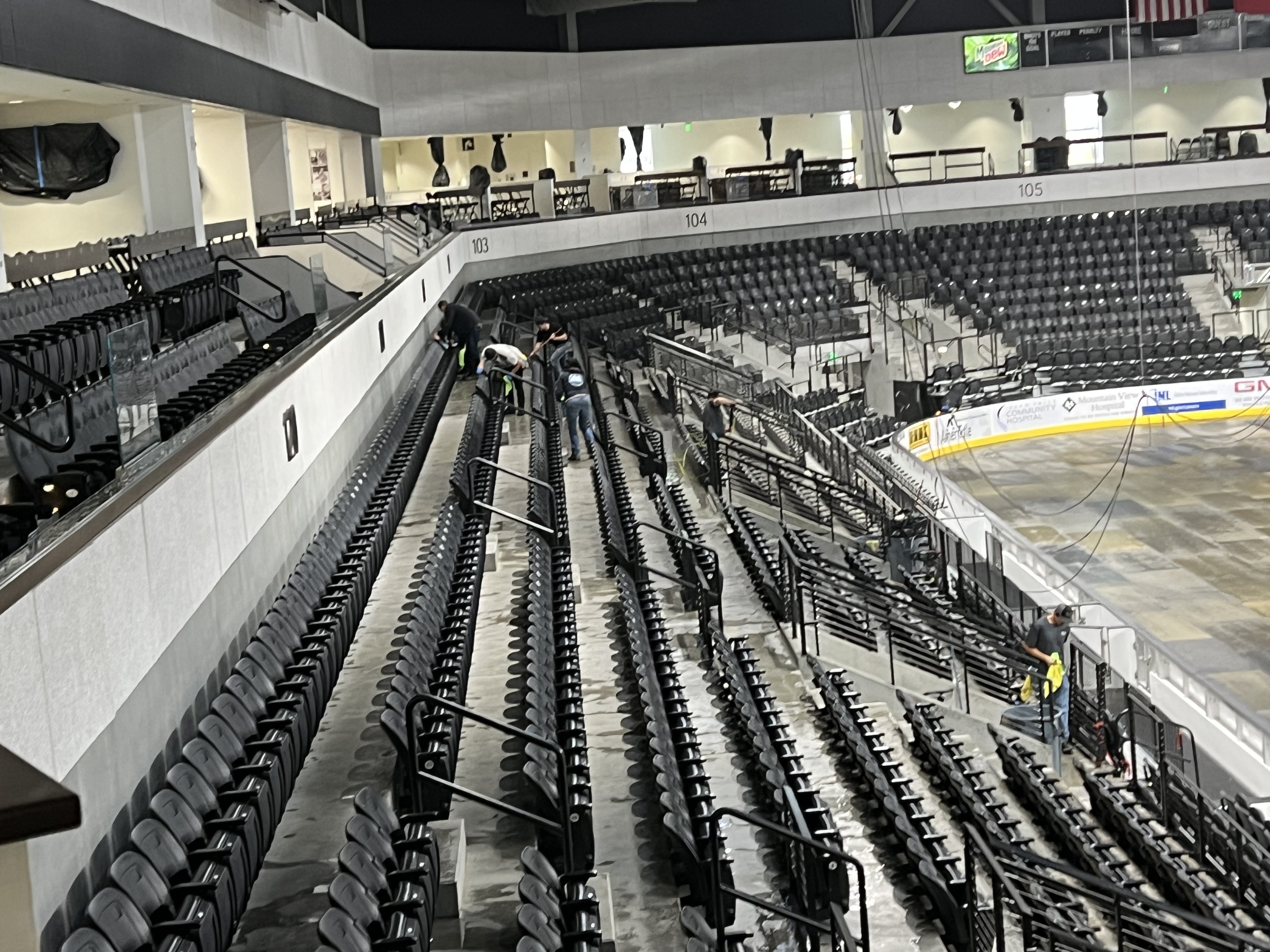 Hi-Teck crew members cleaning rows of seats in an arena