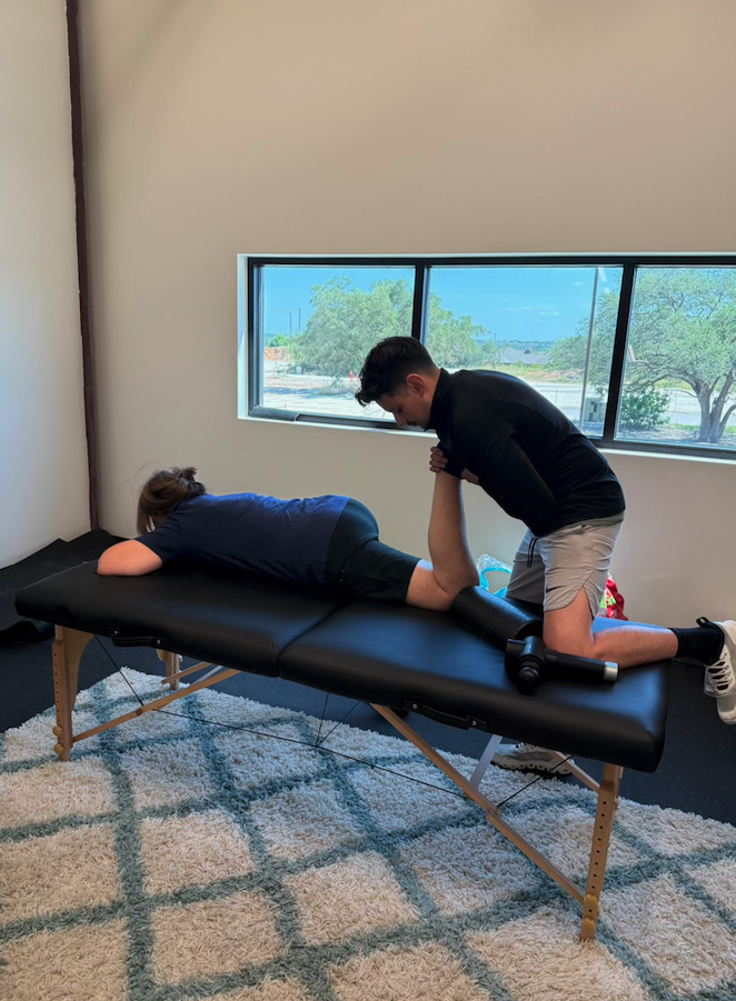 An assisted stretch session on the treatment table at The Lab