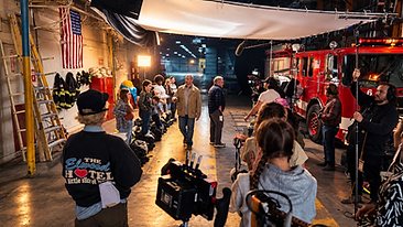 Behind the scenes at Firehouse Six with cast member walking through a working film set