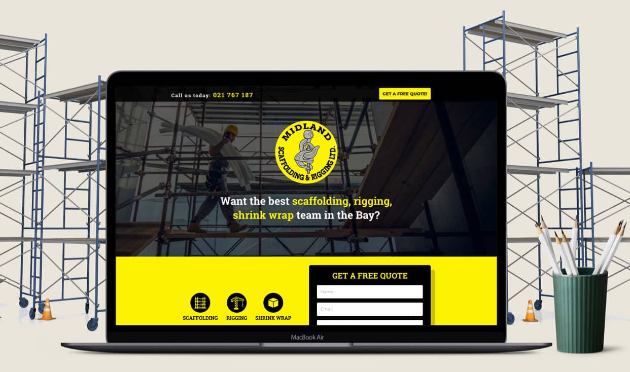 A laptop showing the Midland Scaffolding & Rigging landing page, photographed against a scaffolding site.