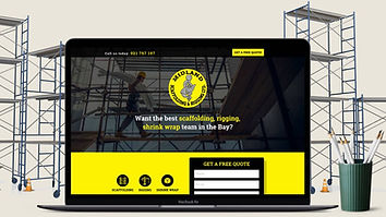 A laptop showing the Midland Scaffolding & Rigging landing page, photographed against a scaffolding site.
