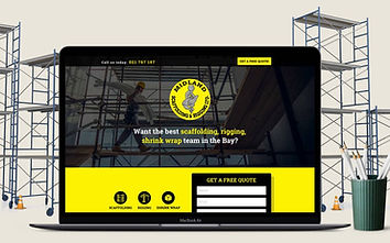 A laptop showing the Midland Scaffolding & Rigging landing page, photographed against a scaffolding site.