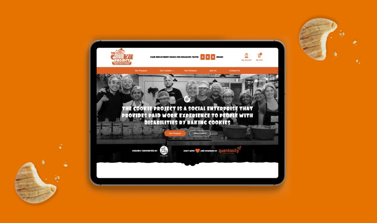 A tablet showing The Cookie Project online store against an orange brand backdrop.
