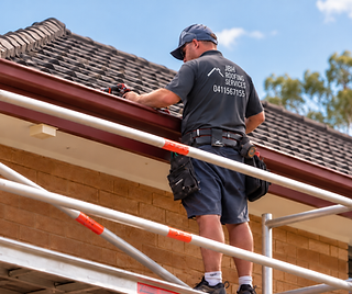 JBH Roofing technician working on a suburban gutter installation