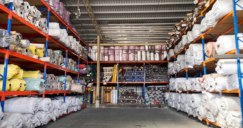 KK Floor warehouse aisle lined with flooring rolls