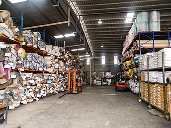 Inside the KK Floor warehouse with stocked shelving and forklifts