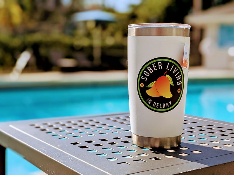 Sober Living in Delray branded tumbler by the pool