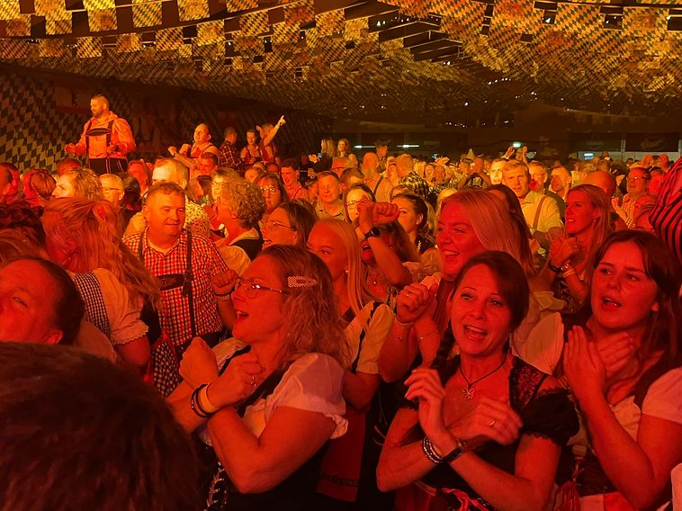 Overblik over det fyldte festtelt med bayerske flag i loftet