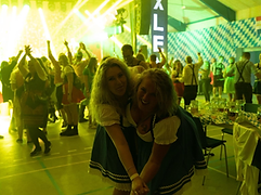 To gæster i dirndl foran XLENT-banneret