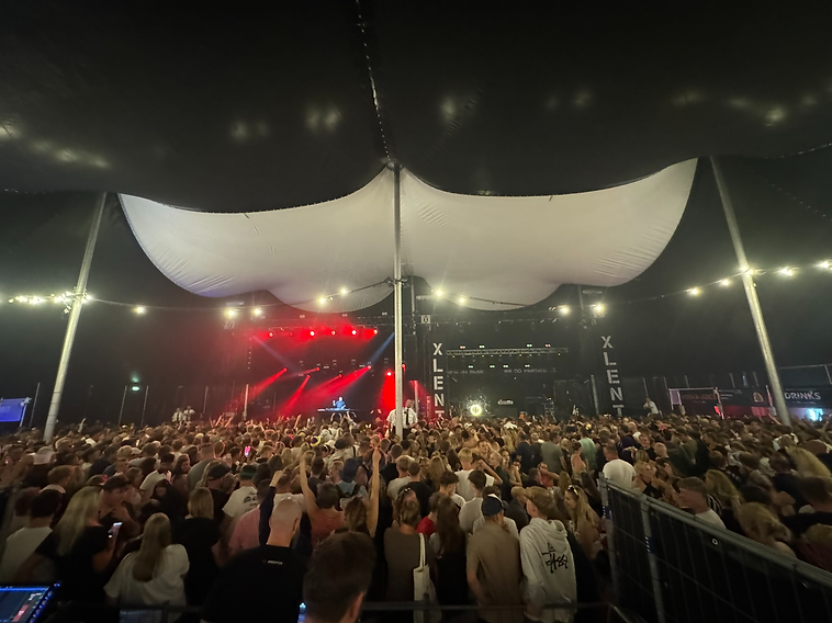 XLENT Live på scenen med rødt lys og telttag