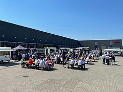 Udendørs firmafest med gæster ved ølborde og foodtrucks