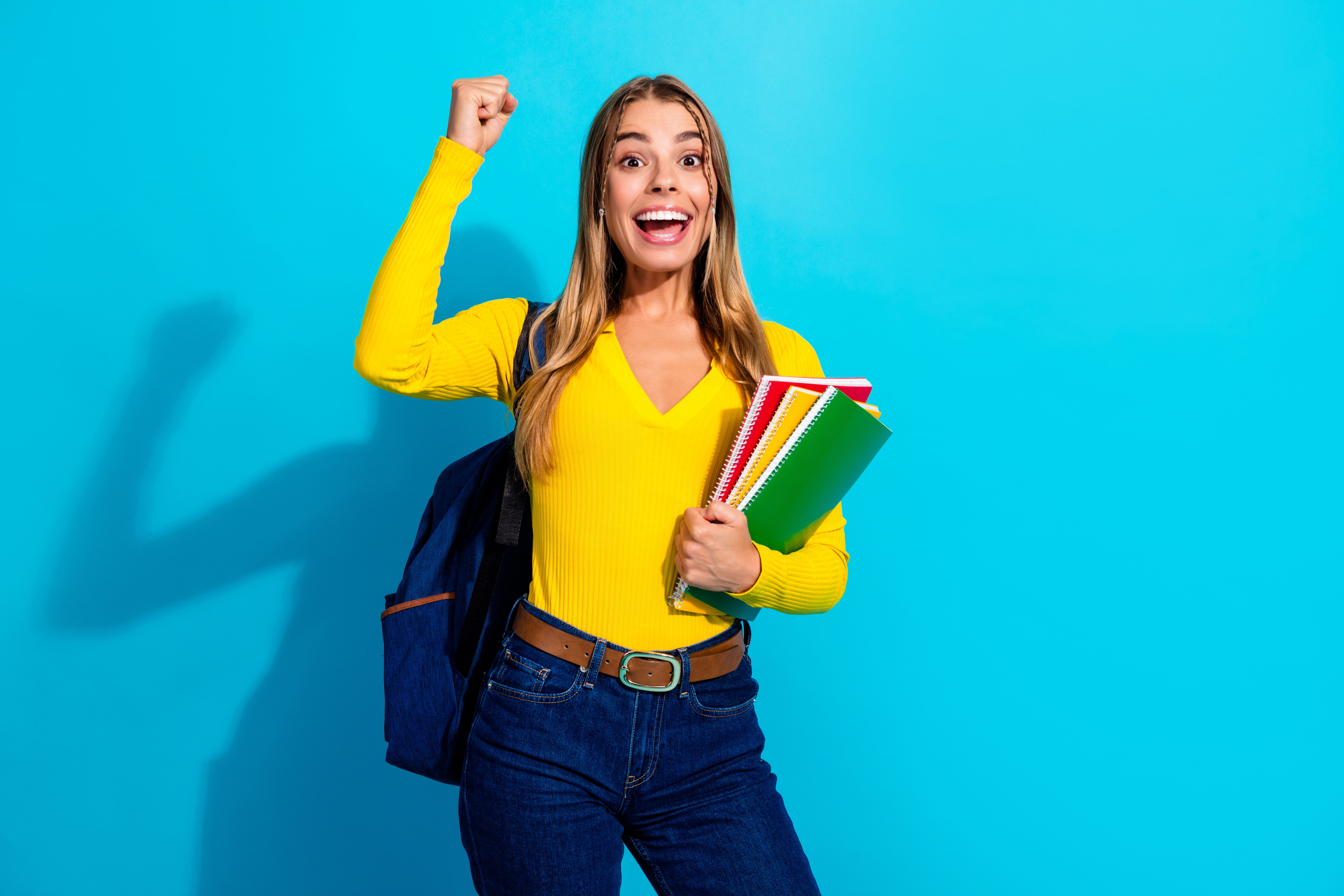 Studentin mit Büchern freut sich über einen Ferienjob