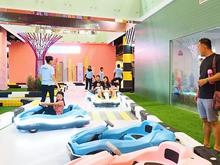 Kids driving electric cars on the VroomTown Singapore track