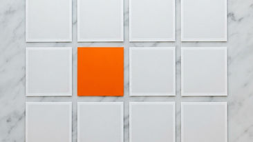 Empty square photo layers on light marble with a single orange layer in between