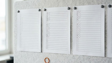 Checklists with marked boxes and empty rows pinned to a board