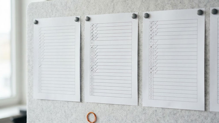 Checklists with marked boxes and empty rows pinned to a board