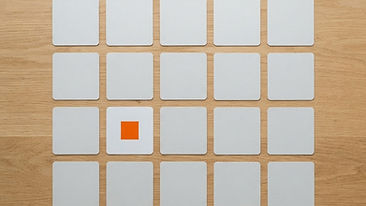 Blank square photo cards arranged as a social media grid on a light wooden table