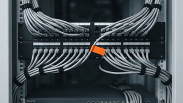 Network patch panel with organized cable management beside modern sleek servers