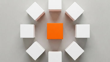 A top-down view of seven white cubes arranged in a circle around a single orange cube in the center.