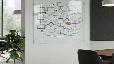 A glass board featuring abstract strategy arrow graphics in the corner of a clean, modern meeting room.