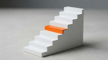 A small nine-step white staircase on a studio background with one orange step