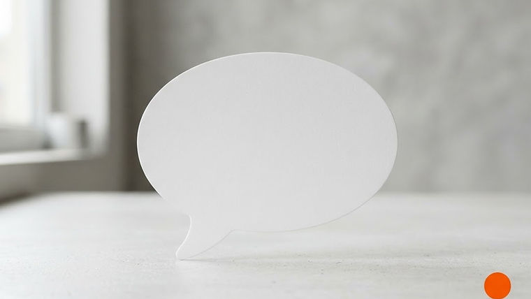A blank speech bubble card resting on a minimalist desk with clean studio lighting