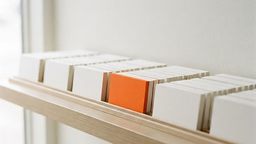 Rows of blank index cards arranged like search results on a light shelf, with one card highlighted in orange.