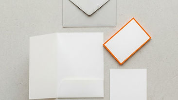 Blank visual identity papers neatly arranged on a light surface with an orange accent