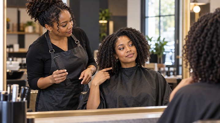 African-American hairstylist consulting with a client about haircut length before the service.