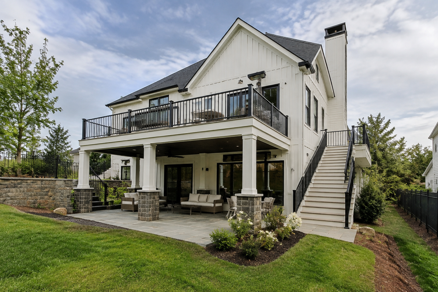 Modern farmhouse two-level deck with white and black trim and stone accents