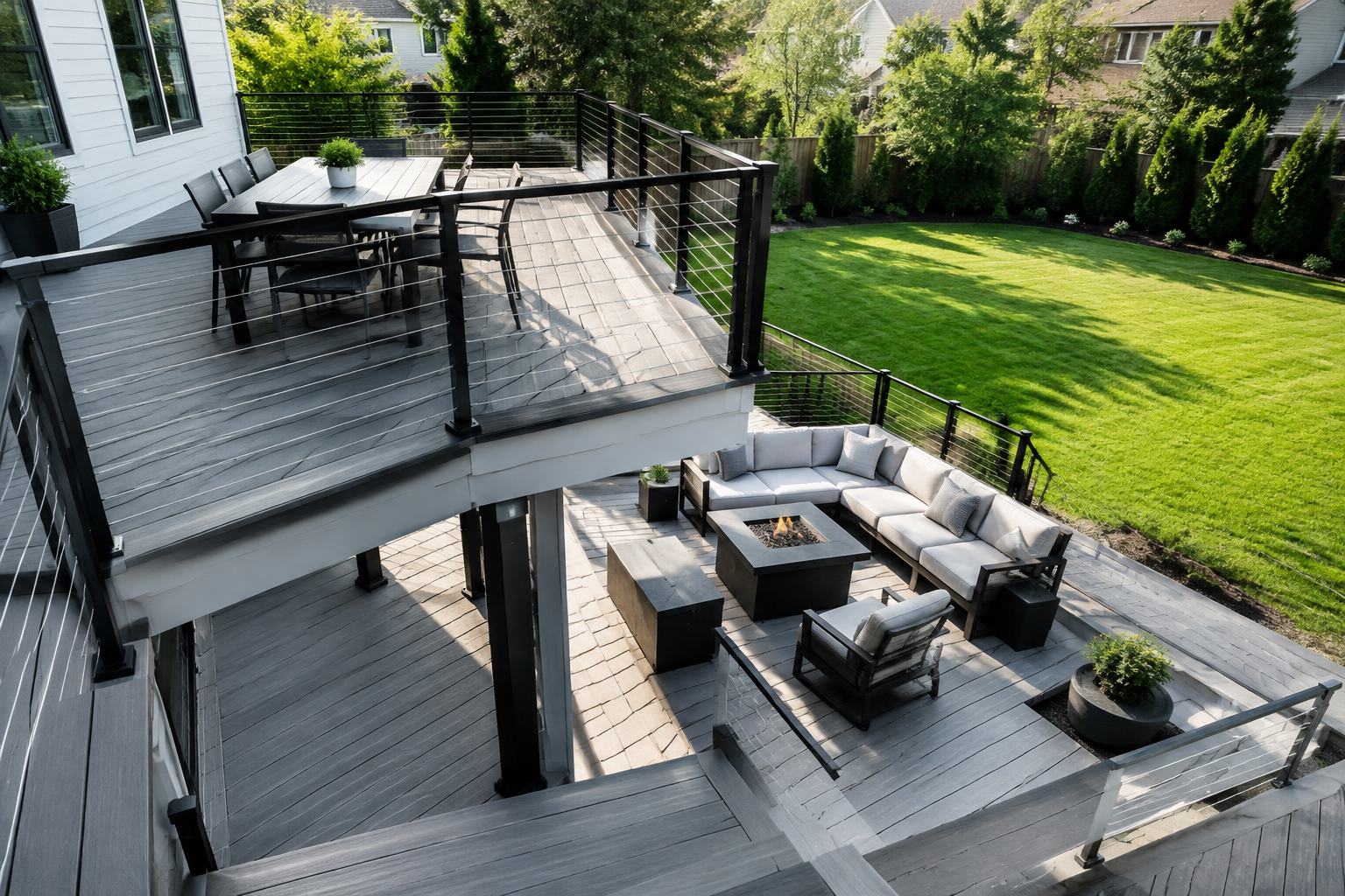 Modern minimalist two-level deck with gray composite boards and black cable railings