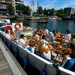 Gasten met een drankje aan boord in de haven van Antwerpen