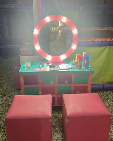 Estação de maquiagem infantil com espelho iluminado e pufes para festas