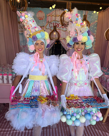Recreadoras caracterizadas de algodão doce distribuindo doces em festa infantil