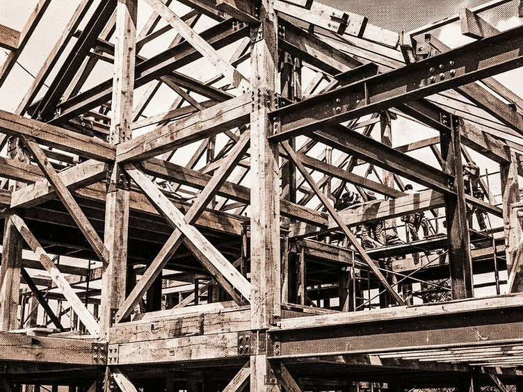 Structural steel frame of a modern commercial building under construction against a clear Alberta sky
