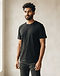 Unisex Essential Cotton Blend Tee — Black (Black), worn or held by model