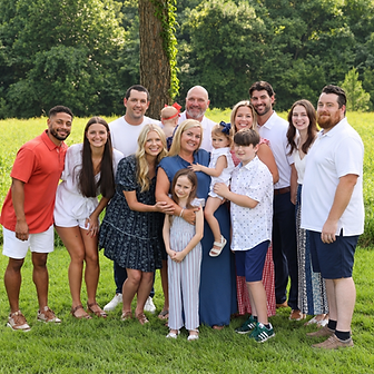 A family portrait outdoors in a grassy field