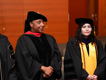 Three TIUAC doctoral honorees in doctoral tams and gowns with gold tassels