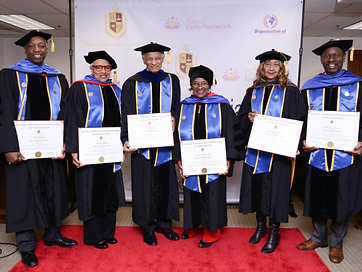 Six TIUAC graduates holding framed diplomas before the Trinity International University of Ambassadors backdrop