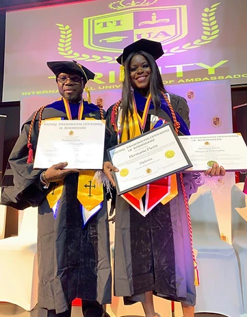 Two TIUAC doctoral graduates holding diplomas before the Trinity International University of Ambassadors stage backdrop